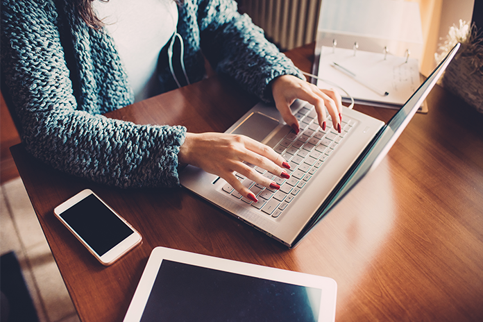 Close up on the hands of young woman using computer