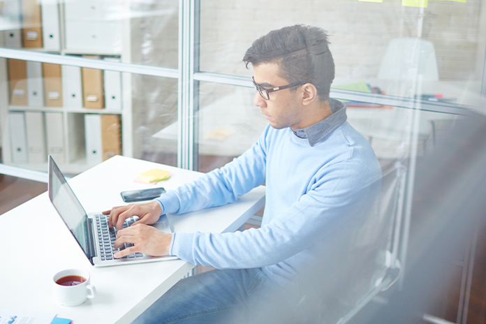 young man working on laptop on his desk